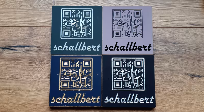 Image: Impressions of coloured engravings of the name "Schallbert" and the QR-code to this website.